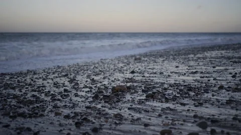 Slow motion waves on stoney beach at magic hour. Video stock 150290007