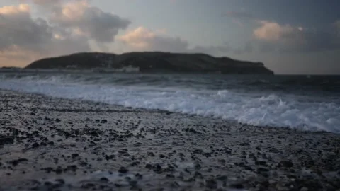 Slow motion waves on stoney beach at magic hour, LLandudno. Video stock 150290202