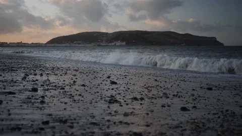 Slow motion waves on stoney beach at magic hour, LLandudno. Video stock 150290431