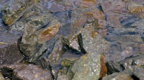 Slow Motion Waves Wash Over a Rocky Beach Stock Footage 65523556