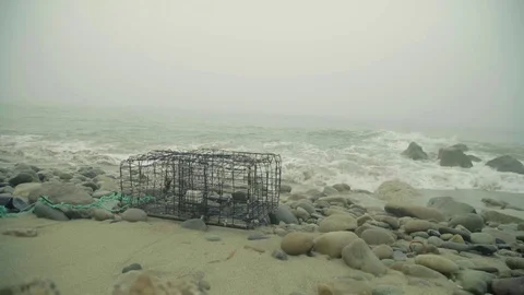 Slow Motion Waves Washing Up on Crab Cage on Beach Stock Footage 72643768