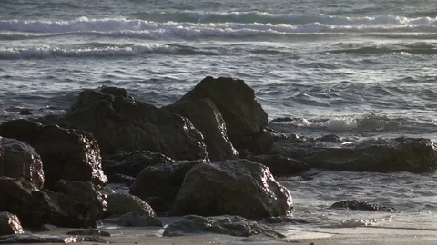 Slow Motion Waves Washing Over Rocky Shore Видео 78211077
