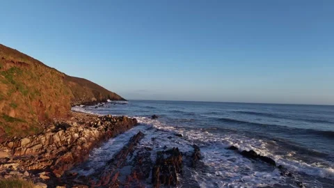 Slow Motion Waves Washing Over Rocky Shoreline in 4K Vidéo 332944180