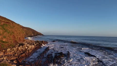 Slow Motion Waves Washing Over Rocky Shoreline in 4K Stock Footage 332944191