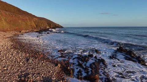 Slow Motion Waves Washing Over Rocky Shoreline in 4K Stock-Footage 332944376
