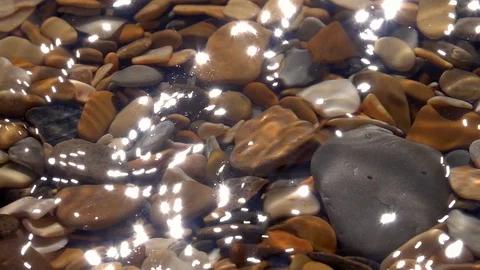 Slow motion of waving dusty surface on shallow water with brown shingle bottom. Stock Footage 98096670