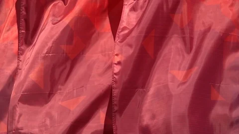 Slow motion of waving red and orange banner cloth in wind close up. Stock Footage 90565870