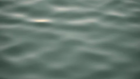 Slow motion of wavy water with the reflection of yellowish sunlight Stock Footage 253453298