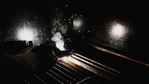 Slow motion of welder completing his welding job with red hot metal fading away  Video stock 102573311