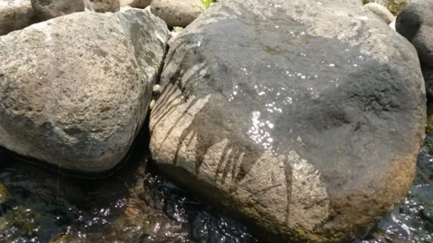 Slow motion of wetting dry river rocks Stock Footage 323149621