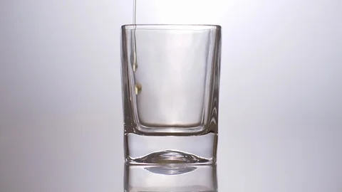 Slow Motion Whiskey Pour on White Background Stockbeeldmateriaal 116690972