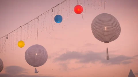 Slow motion of white and colored lamp lanterns blowing in the wind at sunset Video stock 54592797
