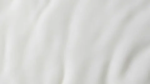 Slow motion white liquid cream ripples, close-up fresh milk drink splash texture Video stock 245409093