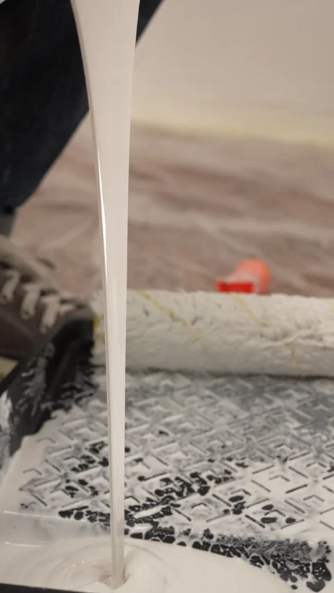 Slow motion. White paint pouring into black tray, close-up. House painter, .. Stock Footage 338243189