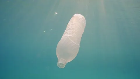 Slow motion, White plastic bottle drift under surface of water in sunrays Stock Footage 242671276