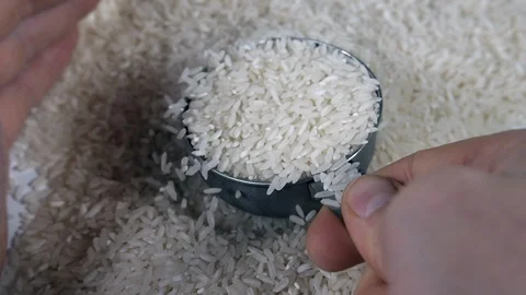 Slow motion white rice with a stainless steel measuring utensil shaking around Stock Footage 88344420