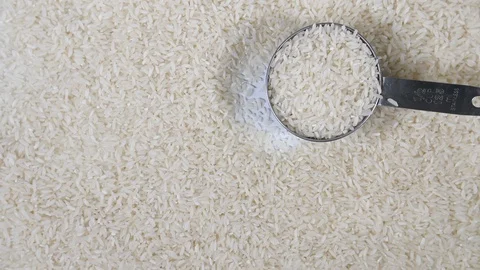 Slow motion white rice with stainless steel measuring utensil, white background Stock Footage 88518891