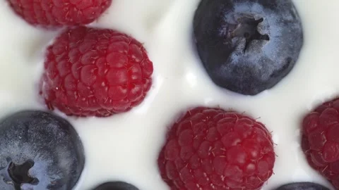 Slow motion of white yogurt with raspberry and blueberry, top view, rotatio.. Stock Footage 278348872
