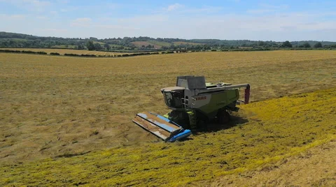 Slow motion wide aerial drone footage of a Claas combine harvester Stock Footage 59864653