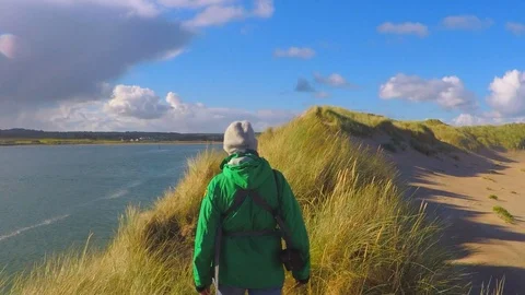 Slow Motion Wide angle shot of Woman taking healthy dog walk through long grass Stock Footage 96713036