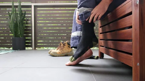 Slow motion wide of construction worker putting on their work socks  Stock Footage 239966858
