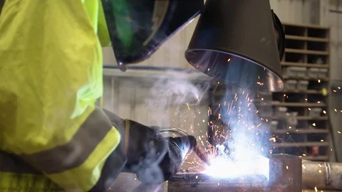 Slow motion wide shot of funnel extracting fumes from welding operation. Stock Footage 93099435