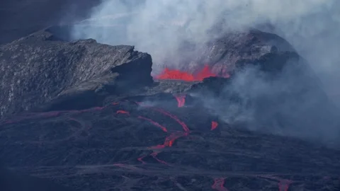 Slow Motion wide shot of spewing volcano crater spewing red fire lava. Stock Footage 156430879