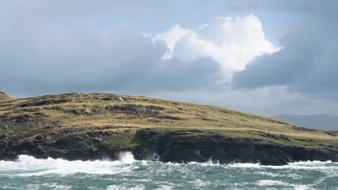 Slow motion wide waves blast against sunny hillside in Ireland Stock Footage 169895597