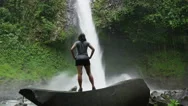 Slow Motion Wide Zoom In Of Hiker Admiring Waterfall In Rain Forest / Arenal, La Stock Footage
