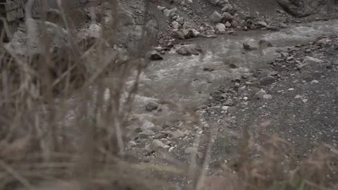 Slow Motion Wild Grey River flows between Rocky Shores of Mountain Stones 2 Stock Footage 239858001