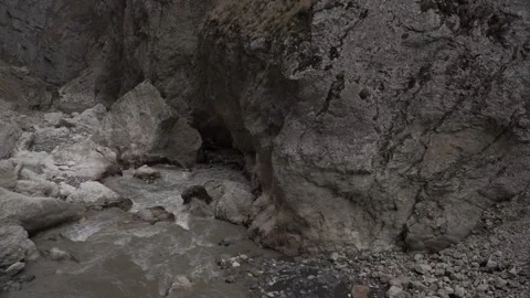 Slow Motion Wild Grey River flows between Rocky Shores of Mountain Stones 1 Stock Footage 239858012