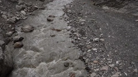 Slow Motion Wild Grey River flows between Rocky Shores of Mountain Stones 3 Stock Footage 239858035