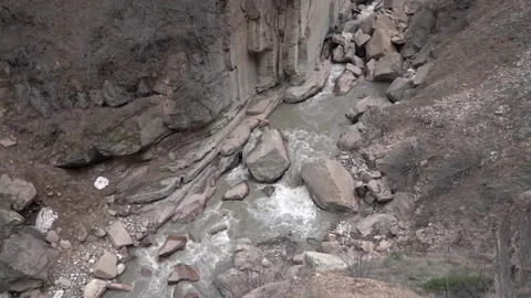 Slow Motion Wild Grey River flows between Rocky Shores of Mountain Stones 5 Stock Footage 239858158