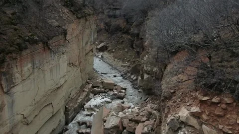 Slow Motion Wild Grey River flows between Rocky Shores of Mountain Stones 7 Video stock 239859094