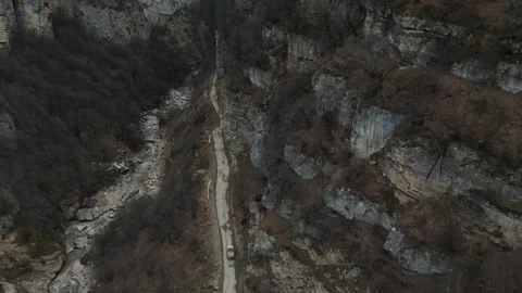 Slow Motion Wild River and road between Rocky Shores of Mountain Stones Stock Footage 239858859