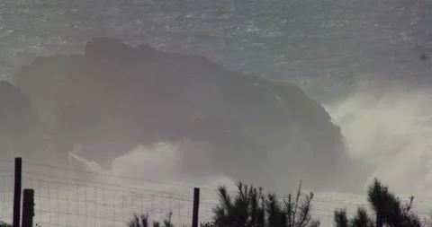 Slow motion of wilding ocean waves splashing high against rocky cliffs in ocean Stock Footage 156133921