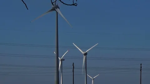 Slow motion wind turbines eco renewable energy blue sky white clouds power lines Stock Footage 101543253