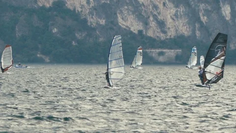 Slow motion windfoil windsurfers on Lake Garda with mountains in background 3 Stock Footage 117833183