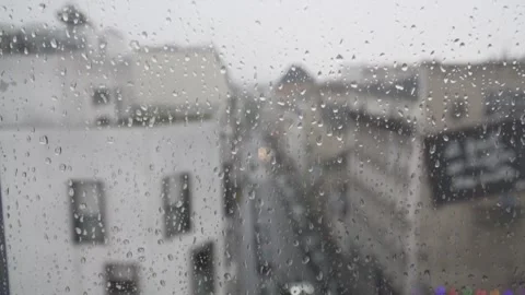 Slow Motion A window with raindrops flowing in the foreground and the city o Stock Footage 271141491