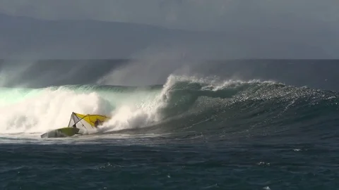 Slow motion windsurfer crashes on a giant wave in Hawaii, extreme sport Stock Footage 77611043