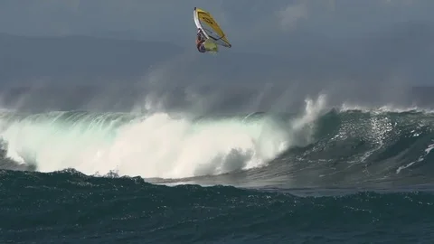 Slow motion windsurfer launching off giant wave in Hawaii Stock Footage 77611052