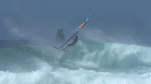 Slow motion windsurfer turns and jumps of giant wave in Hawaii, Extreme Sport Stock Footage 77611053