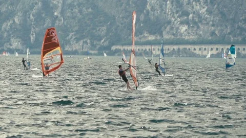 Slow motion windsurfers on Lake Garda with mountains in background Stock Footage 117832963