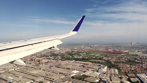 Slow motion. The wing of an aircraft flew above industrial estate. Stock Footage 246931824