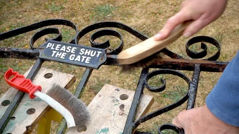Slow motion: Wire brush in use on a rusty gate. Stock Footage 92016778