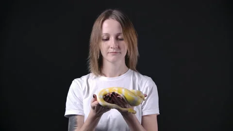 Slow motion of woman with albino python in her hands 動画素材 143957577