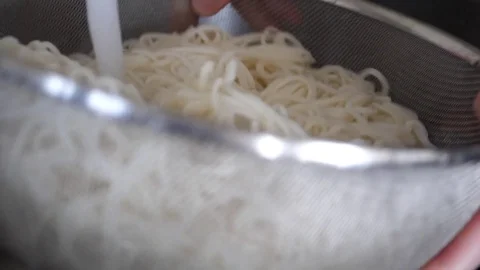 Slow motion of woman draining cooked noodles Stock Footage 76340254