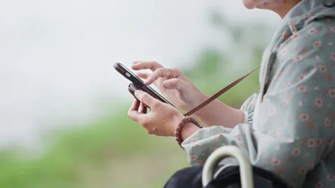 Slow motion of woman using smartphone at Ohori Park, Fukuoka Stock Footage 323215689