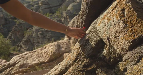 Slow motion. Woman's hand with red nail polish touching rock. Stock Footage 141794775