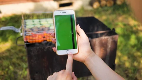 Slow motion woman's hand using a phone with vertical green screen on the Stock Footage 94233278